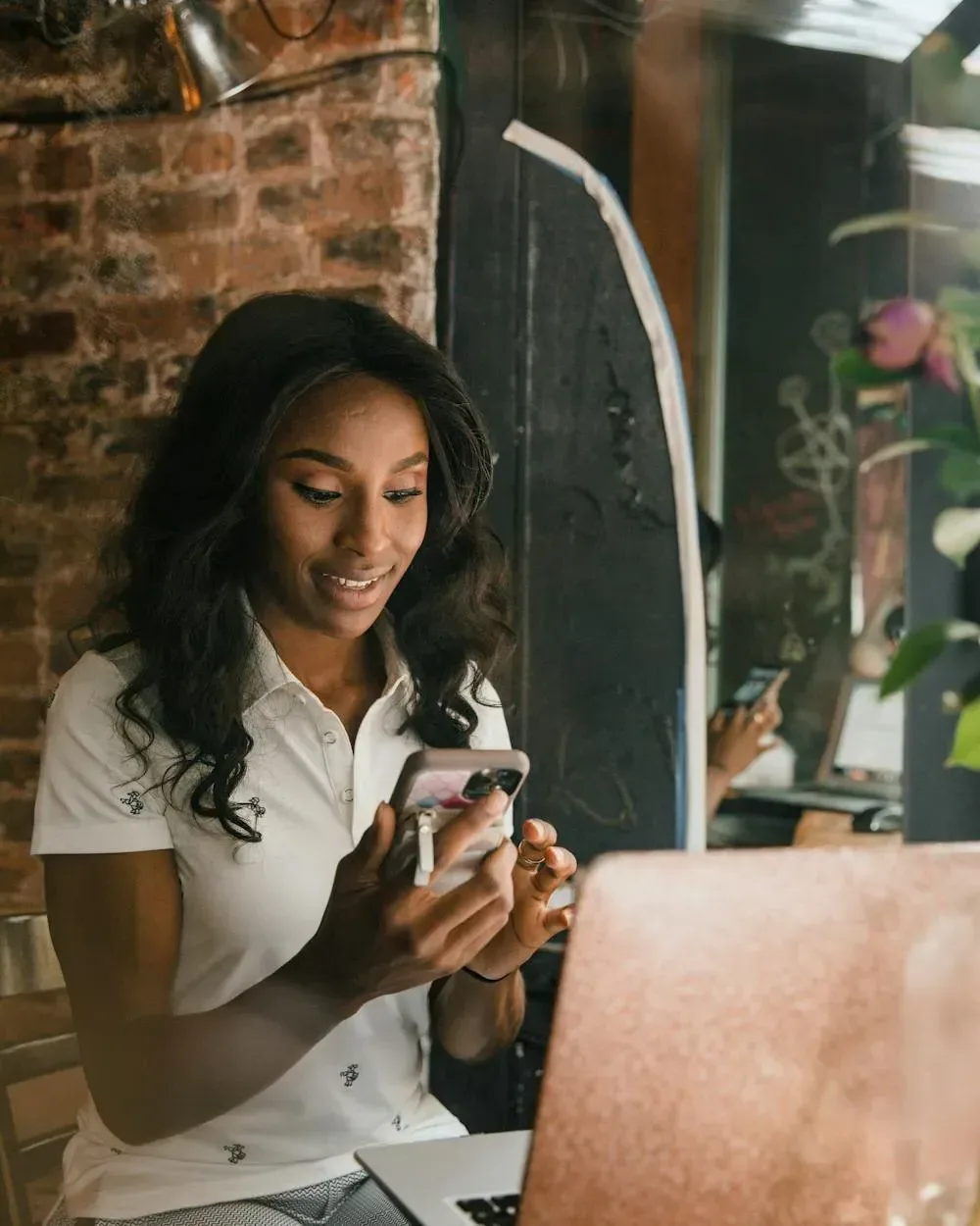 A boutique owner holding a phone showing their store app